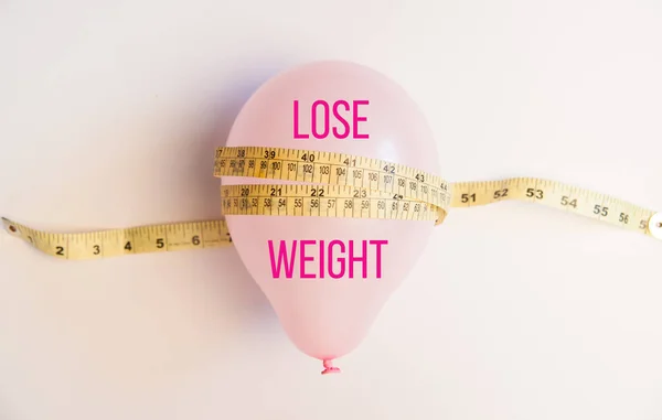 Idea of weight loss. Balloon with measuring tape. Lose weight text