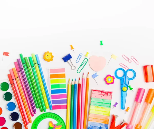 School stationery products such as paper clips, pins, notebooks, pens, pencils, rulers, scissors lying on white table with space to write your text