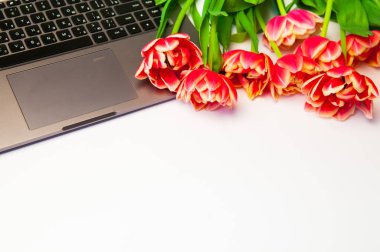 güzel laleler ve ahşap arka plan üstünde laptop