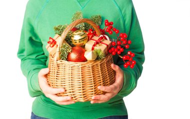 Adam yeşil kazaklı sepet beyaz arka plan üzerinde izole Noel süslemeleri ile tutarak