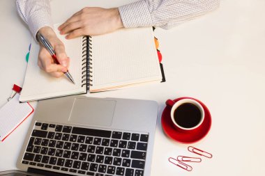 Masada dizüstü bilgisayar ve ofis malzemeleri ile çalışan adam