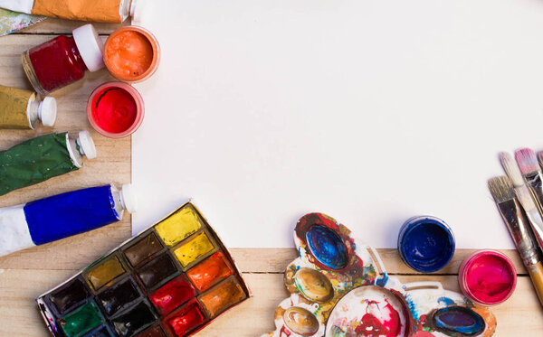 Краски, кисти на деревянном фоне. Рабочее место художника. Знамя для школы
. 