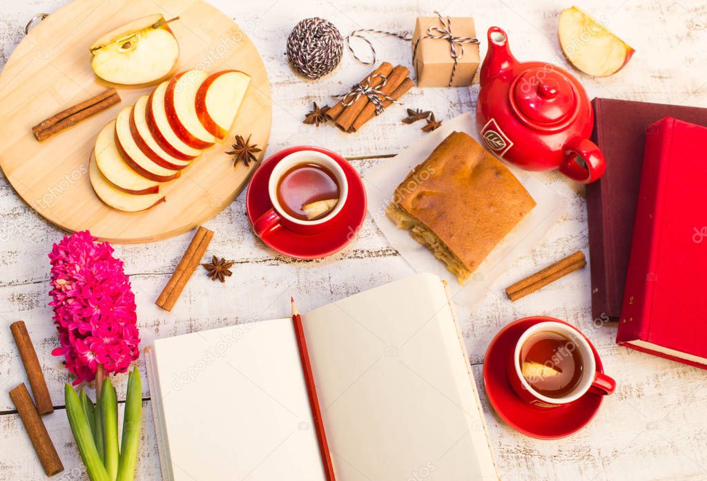 gift, books, notepad, apple, tea, flower  on wooden table