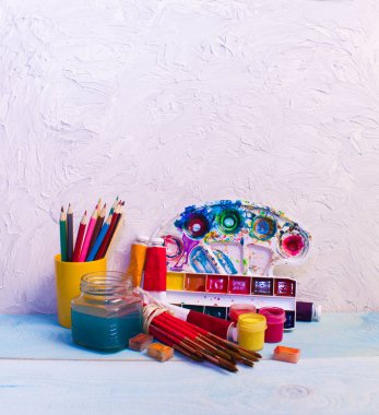 Paints, brushes, pencils on the wood background. The workplace of the artist. Banner for school.  clipart