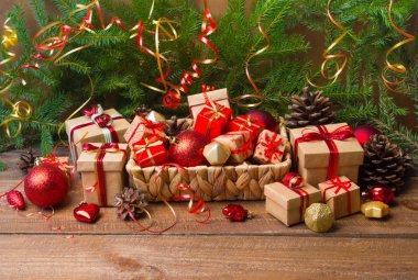 Noel ve yeni yıl arka plan: cam oyuncaklar, süslemeleri ve hediyeler ahşap arka plan üzerinde renkli