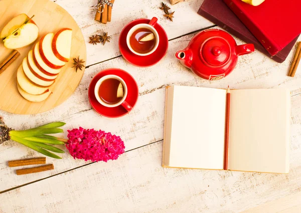 notepad, apple slices, tea, flower  on wooden table