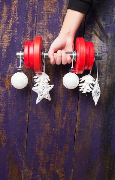 Noel ve yeni yıl menekşe ahşap arka plan üzerinde. Sağlıklı yaşam ve spor için dumbbells ile kompozisyon