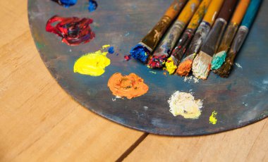 Boya fırçaları ahşap arka plan üzerinde paletle  