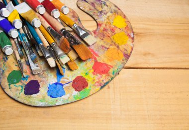 Boya fırçaları ahşap arka plan üzerinde paletle  