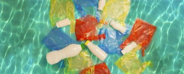 Renkli paketleri ve okyanus su beyaz plastik şişelerde. Kirliliği kavramı.