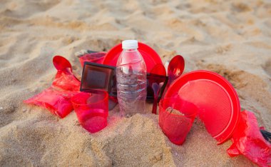 kumlu plajda kırmızı plastik bulaşık yakından görünümü