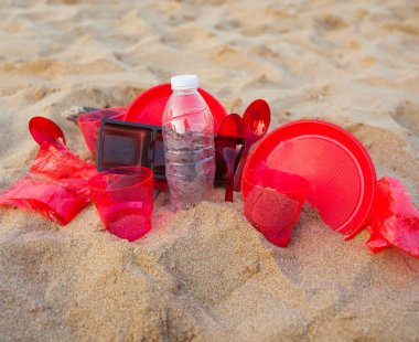 kumlu plajda kırmızı plastik bulaşık yakından görünümü
