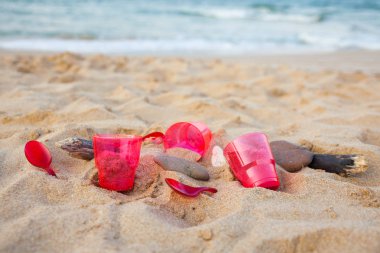 kumlu plajda kırmızı plastik bulaşık yakından görünümü