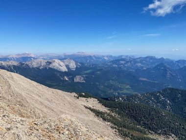 Dağların panoramik manzarası ve Tahtali 'nin zirvesinden Kemer kıyıları. Olympos Teleferik, Tahtali 2365 metre, Kemer, Antalya, Türkiye. Denizden gökyüzüne.