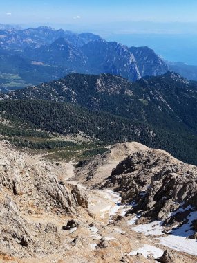 Dağların panoramik manzarası ve Tahtali 'nin zirvesinden Kemer kıyıları. Olympos Teleferik, Tahtali 2365 metre, Kemer, Antalya, Türkiye. Denizden gökyüzüne.
