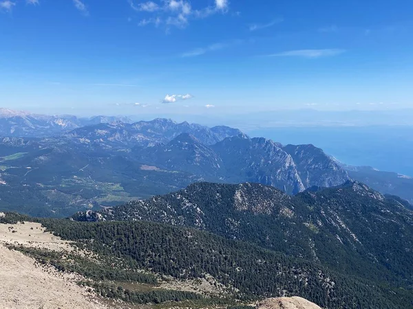 Dağların panoramik manzarası ve Tahtali 'nin zirvesinden Kemer kıyıları. Olympos Teleferik, Tahtali 2365 metre, Kemer, Antalya, Türkiye. Denizden gökyüzüne.