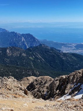 Dağların panoramik manzarası ve Tahtali 'nin zirvesinden Kemer kıyıları. Olympos Teleferik, Tahtali 2365 metre, Kemer, Antalya, Türkiye. Denizden gökyüzüne.