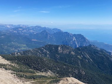 Dağların panoramik manzarası ve Tahtali 'nin zirvesinden Kemer kıyıları. Olympos Teleferik, Tahtali 2365 metre, Kemer, Antalya, Türkiye. Denizden gökyüzüne.
