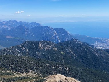 Dağların panoramik manzarası ve Tahtali 'nin zirvesinden Kemer kıyıları. Olympos Teleferik, Tahtali 2365 metre, Kemer, Antalya, Türkiye. Denizden gökyüzüne.