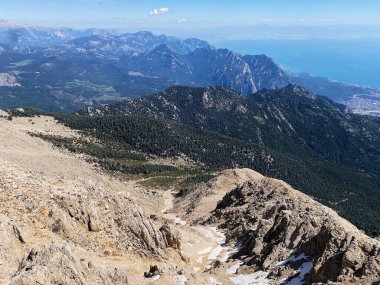 Dağların panoramik manzarası ve Tahtali 'nin zirvesinden Kemer kıyıları. Olympos Teleferik, Tahtali 2365 metre, Kemer, Antalya, Türkiye. Denizden gökyüzüne.