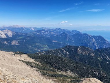 Dağların panoramik manzarası ve Tahtali 'nin zirvesinden Kemer kıyıları. Olympos Teleferik, Tahtali 2365 metre, Kemer, Antalya, Türkiye. Denizden gökyüzüne.