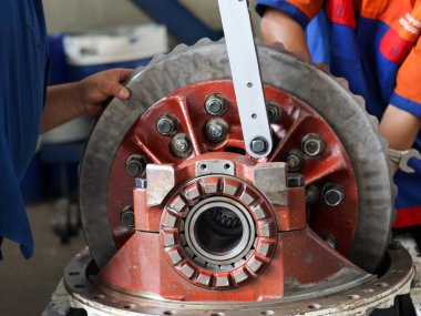 Bir tamirci diferansiyel başlık dişlilerinin vidalarını sıkmak için büyük bir tork anahtarı kullanır, endüstriyel onarım ve makine bakımını gösterir..