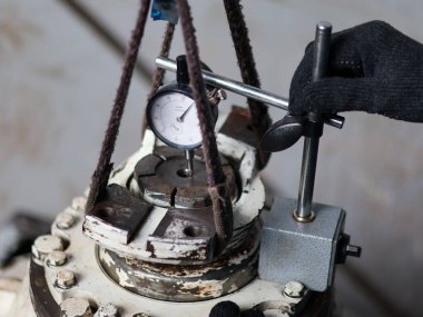 Bir işçi, ters çıkış diferansiyelini tam olarak ölçmek için bir çevirme göstergesi ve özel bir jig kullanır.