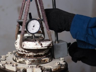 Bir işçi, ters çıkış diferansiyelini tam olarak ölçmek için bir çevirme göstergesi ve özel bir jig kullanır.