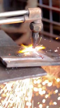 Parlak kıvılcımlar saçan metali kesen bir meşale asetilen gazı sert bir endüstriyel ortamda havada uçuşuyor ve etrafa sıçrıyor..