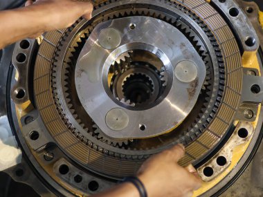 Yaylı, metal debriyajlı, hassas mühendislik ve mekanik detayları vurgulayan otomatik iletim gezegen teçhizatı montajının yakın çekimi.