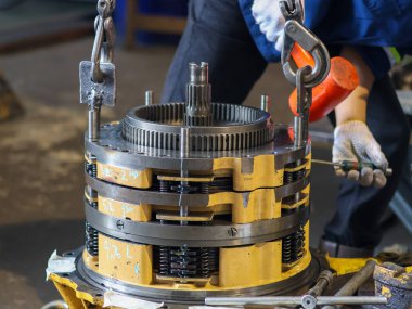 Gezegen teçhizat montajını zincir çekiş, makine mühendisliği ve makine bakım sürecini vurgulayan işçiler.