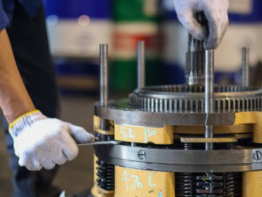 Mekanik el şanzıman gezegen teçhizatını söküyor, hassas mühendislik ve mekanik detayları vurguluyor..