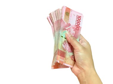 Close-up of hand holding a stack of Indonesian Rupiah banknotes. Crisp focus on red bills against white background. Perfect for finance, wealth, banking, business, and economic concepts.