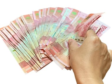 Hand holds the spreading Indonesian 100,000 rupiah bills isolated on white background. Sharp detail, natural light, perfect for finance, economy, banking, salary, savings, and wealth themes.