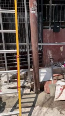 Jakarta, Endonezya. 12 Eylül 2025. PLN 'den elektrik işçisi direğin tepesindeki kabloları kontrol ediyor. Aşağıdan çekilmiş, şehir manzarası. Kavram: altyapı, güvenlik, elektrik, vb.