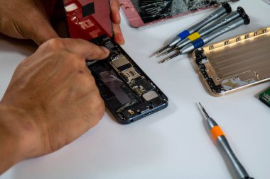 Bir adam yeni bir cep telefonu ekranı yüklüyor. Ekranı hasar gördükten sonra