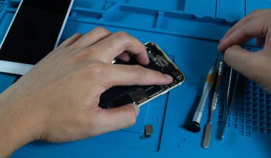 Bir mobil tamirci zaten yeni parçaları yerini sonra bir cep telefonu ile yeni bir cep telefonu kamera montaj.