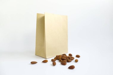 Kahverengi kağıt torba yanında badem kazık makro fotoğrafı.