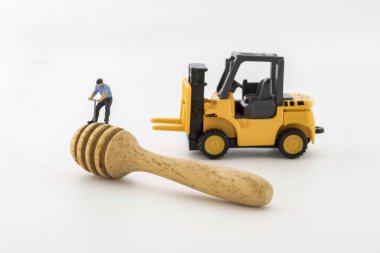 ahşap beyaz arka plan üzerine kaşıkla minyatür işçisi yapılmış.