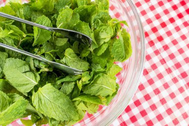 Nane yaprakları kapatın. Bir cam kabın içinde yemek pişirmek için.