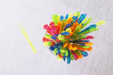 Renkli plastik çatal ahşap masa üzerinde kareli bir fincan. çatal