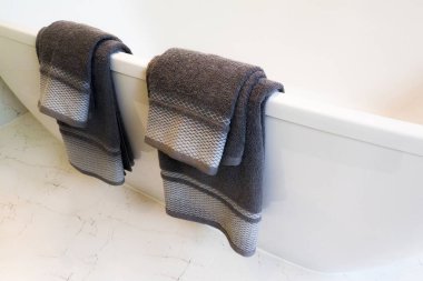 Koyu gri havlu banyoda küvet asılı.