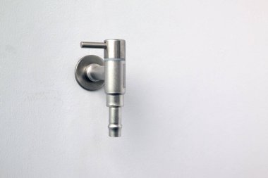 Gümüş su musluğu kapat veya küme kadar bina dışında beton duvar dokunun.