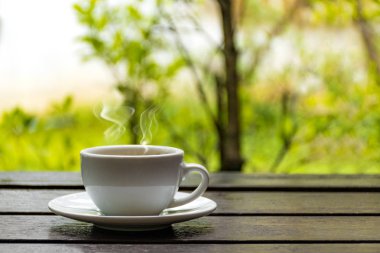 Sonbahar arka plan üzerinde beyaz kahve fincanı. Güzel kahve fincanı ile doğa arka plan ve sıcak içinde belgili tanımlık bahçe mutlu ışık.