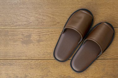 Ahşap zemin üzerinde siyah closeup otel terlik. Üstten görünüm. Kopya alanı.