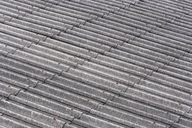 Arka planda kalıpla kaplanmış eski arduvaz çatıparçaları. Dalgalı dokuya sahip soyut gri arka plan