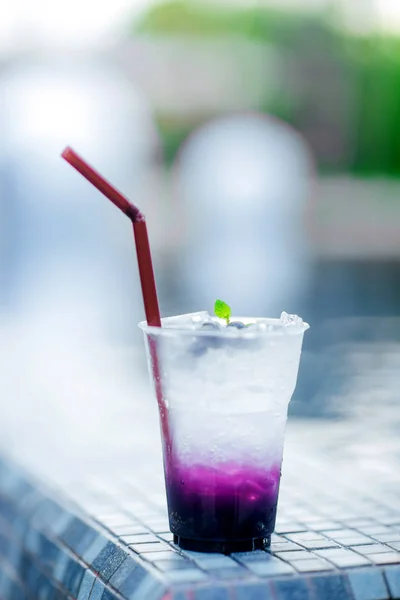 Fresh cold drink with blueberry and sweet soda, cold at the pool. Healthy beverage in a rustic style. Trendy lifestyle drink.