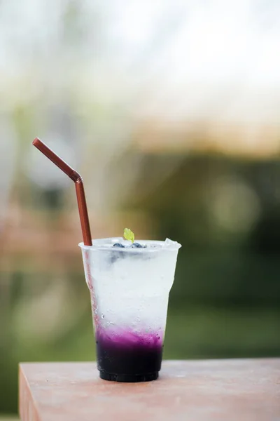 Fresh cold drink with blueberry and sweet soda, cold at the pool. Healthy beverage in a rustic style. Trendy lifestyle drink.