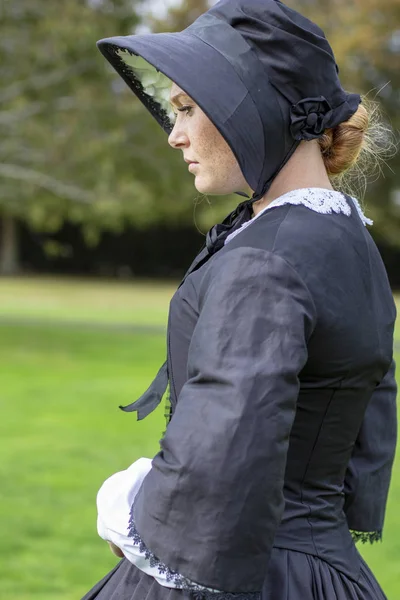 Victorian woman in black dress and bonnet