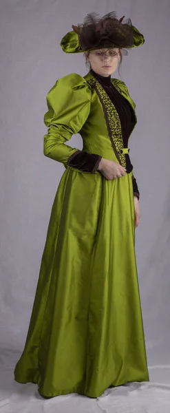 维多利亚时代的女人穿着绿色19世纪90年代合奏与腿 羊肉袖子 — 图库照片